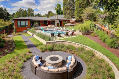Example of a large minimalist backyard tile patio design in Portland with a fireplace and a roof extension