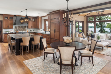 Large country l-shaped eat-in kitchen in Minneapolis with recessed-panel cabinets, medium wood cabinets, panelled appliances and with island.