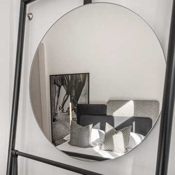 Bedroom Mirror Detail Reflecting Bed and Monochrome Artwork