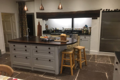 Photo of a medium sized country kitchen/diner in West Midlands with shaker cabinets, grey cabinets, wood worktops, slate flooring, an island, grey floors and brown worktops.
