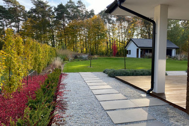 This is an example of a mid-sized contemporary full sun backyard concrete paver landscaping in Other for fall.