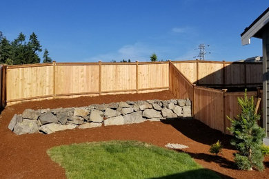 Photo of a mid-sized rustic backyard mulch landscaping in Seattle.