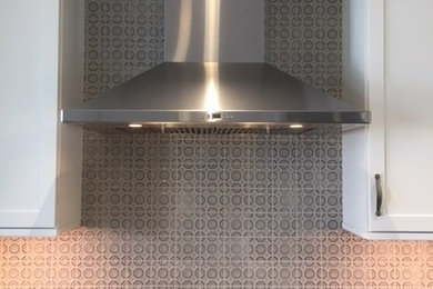 Inspiration for a mid-sized transitional l-shaped medium tone wood floor and brown floor eat-in kitchen remodel in Denver with an undermount sink, shaker cabinets, white cabinets, quartz countertops, gray backsplash, ceramic backsplash, stainless steel appliances, an island and multicolored countertops
