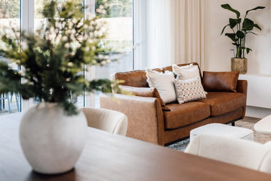 Expansive modern formal and grey and white open plan living room feature wall in Buckinghamshire with white walls, ceramic flooring, a hanging fireplace, a plastered fireplace surround, a wall mounted tv, grey floors and panelled walls.