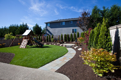 Inspiration for a mid-sized arts and crafts backyard full sun xeriscape for summer in Seattle with natural stone pavers and with outdoor playset.
