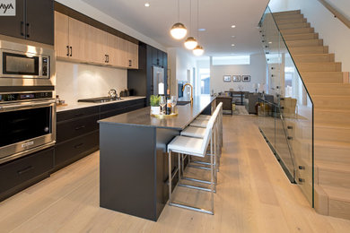 Eat-in kitchen - mid-sized contemporary galley light wood floor and yellow floor eat-in kitchen idea in Other with a farmhouse sink, shaker cabinets, gray cabinets, wood countertops, white backsplash, quartz backsplash, stainless steel appliances, an island and white countertops