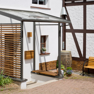 Haustür aus Holz mit Vordach und Verkleidung