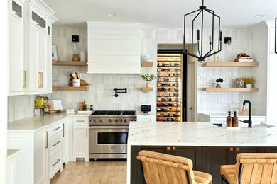 Eat-in kitchen - mid-sized modern l-shaped light wood floor eat-in kitchen idea in St Louis with a farmhouse sink, recessed-panel cabinets, white cabinets, quartzite countertops, white backsplash, subway tile backsplash, stainless steel appliances, an island and white countertops