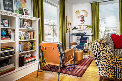 Example of a large eclectic enclosed medium tone wood floor and brown floor family room design in Other with white walls