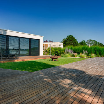 Moderner Seegarten mit großzügiger Holzterrasse