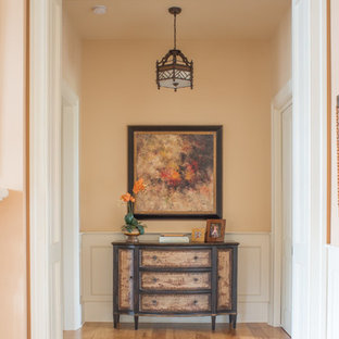 Idéer för att renovera en stor vintage hall, med orange väggar och mellanmörkt trägolv