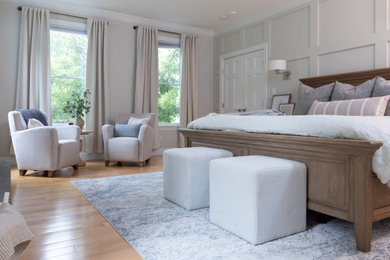 Example of a large transitional master light wood floor and wood wall bedroom design in Philadelphia with gray walls, a standard fireplace and a wood fireplace surround