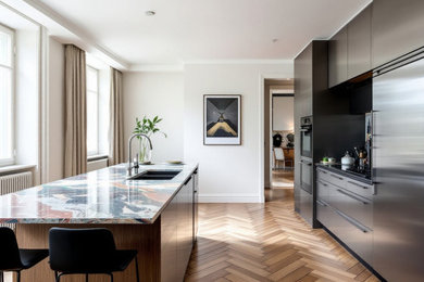 Große Moderne Wohnküche mit Einbauwaschbecken, Marmor-Arbeitsplatte, Küchengeräten aus Edelstahl, braunem Holzboden und Kücheninsel in München