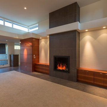 Open living room with built in cabinets, clerestory windows, plant shelf and CMU