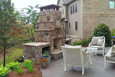 Elegant backyard concrete patio photo in Atlanta with a fire pit and no cover