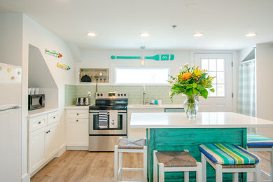 Kitchen - coastal l-shaped medium tone wood floor and brown floor kitchen idea in Boston with an undermount sink, shaker cabinets, white cabinets, green backsplash, subway tile backsplash, stainless steel appliances, an island and white countertops
