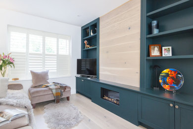 This is an example of a large contemporary open plan living room in Dublin with white walls, laminate floors, no fireplace, a wooden fireplace surround, a built-in media unit, beige floors and panelled walls.