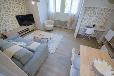Cette photo montre une salle de séjour scandinave de taille moyenne avec du papier peint, un mur beige, parquet clair, aucune cheminée et un sol beige.