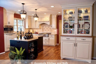 Example of a large classic u-shaped light wood floor and brown floor eat-in kitchen design in Baltimore with an undermount sink, raised-panel cabinets, white cabinets, granite countertops, beige backsplash, stone tile backsplash, stainless steel appliances and an island