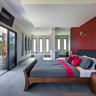 Foto di una camera matrimoniale etnica con pareti rosse e moquette