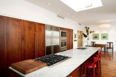 Example of a large transitional single-wall light wood floor and brown floor eat-in kitchen design in Other with an undermount sink, flat-panel cabinets, medium tone wood cabinets, marble countertops, stainless steel appliances and an island