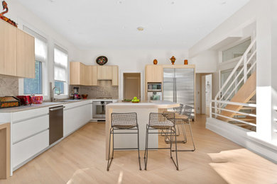 Example of a large minimalist l-shaped eat-in kitchen design in New York with flat-panel cabinets, white cabinets, marble countertops and an island