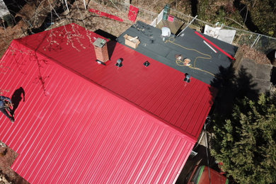 Diseño de fachada de casa roja con tejado a dos aguas y tejado de metal