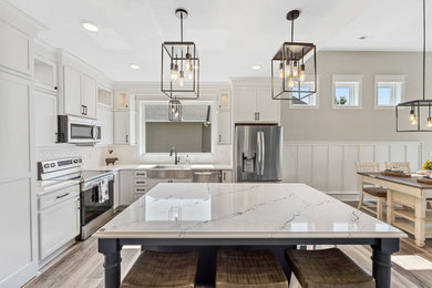 Inspiration for a small transitional l-shaped laminate floor and brown floor eat-in kitchen remodel in Minneapolis with a farmhouse sink, shaker cabinets, white cabinets, quartz countertops, white backsplash, ceramic backsplash, stainless steel appliances, an island and white countertops