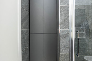 Foto di una stanza da bagno con doccia moderna di medie dimensioni con ante lisce, ante grigie, piastrelle grigie, piastrelle in pietra, lavabo da incasso, top in laminato, top grigio, un lavabo e mobile bagno sospeso