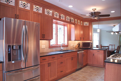 Mid-sized elegant galley porcelain tile and beige floor eat-in kitchen photo in Chicago with shaker cabinets, light wood cabinets, beige backsplash, stainless steel appliances, granite countertops, a drop-in sink, terra-cotta backsplash and an island