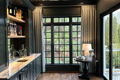 Example of a mid-sized trendy galley dark wood floor and brown floor wet bar design in Atlanta with an undermount sink, shaker cabinets, blue cabinets, granite countertops, glass sheet backsplash and gray countertops