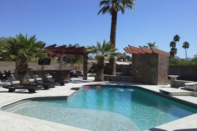 Mid-sized transitional backyard custom-shaped natural pool in Phoenix with a water feature and natural stone pavers.