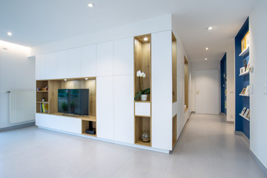 Cette image montre un grand hall d'entrée design avec un mur bleu, un sol en carrelage de céramique, une porte simple, une porte blanche, un sol gris et un plafond à caissons.