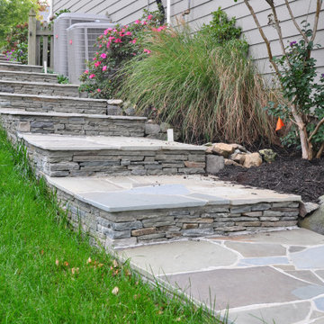Down hill stone steps to the stone patio and fireplace.