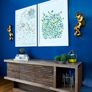 Large transitional formal and enclosed medium tone wood floor and brown floor living room photo in New York with blue walls and a concealed tv