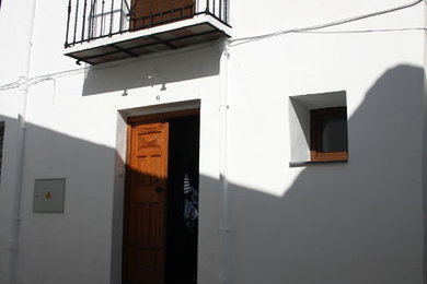 Foto de fachada de casa blanca rústica de tamaño medio de dos plantas con revestimiento de hormigón, tejado plano y tejado de varios materiales