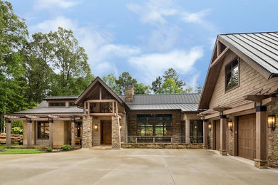 Example of a large mountain style brown two-story mixed siding gable roof design in Other