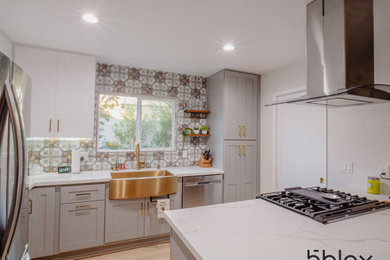 Kitchen - mid-sized contemporary l-shaped medium tone wood floor and brown floor kitchen idea in Orange County with a farmhouse sink, shaker cabinets, gray cabinets, quartzite countertops, multicolored backsplash, ceramic backsplash, stainless steel appliances, a peninsula and white countertops