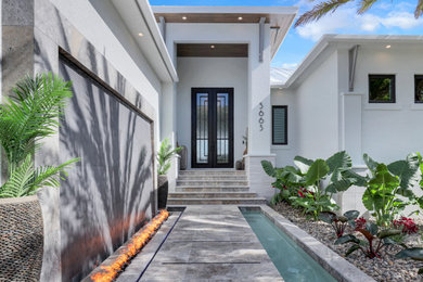 Example of a trendy gray floor and wood ceiling entryway design in Miami with white walls and a metal front door