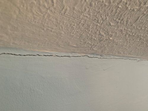 Cracking along wall where ceiling meets