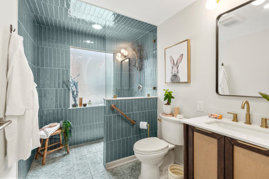 Small master ceramic tile, blue floor and single-sink bathroom photo in New Orleans with recessed-panel cabinets, brown cabinets, white walls, an undermount sink, quartzite countertops, white countertops and a freestanding vanity