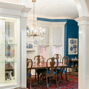 Inredning av en klassisk stor separat matplats, med blå väggar, mörkt trägolv, en standard öppen spis, en spiselkrans i trä och brunt golv