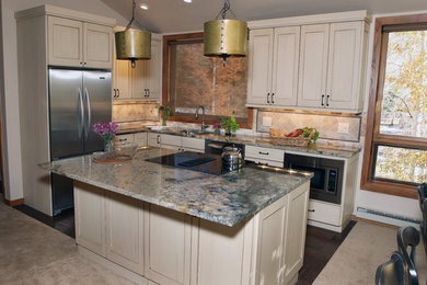 Example of a small classic l-shaped dark wood floor open concept kitchen design in Denver with a drop-in sink, beaded inset cabinets, beige cabinets, granite countertops, beige backsplash, stone tile backsplash, stainless steel appliances and an island