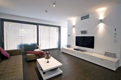 Mid-sized elegant open concept dark wood floor family room photo in Los Angeles with white walls and no fireplace