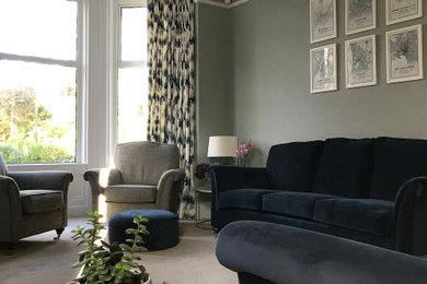 This is an example of a medium sized traditional living room in Belfast with blue walls and carpet.