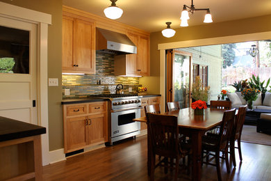 Mid-sized arts and crafts u-shaped medium tone wood floor open concept kitchen photo in Los Angeles with recessed-panel cabinets, light wood cabinets, multicolored backsplash, matchstick tile backsplash, stainless steel appliances, no island and soapstone countertops