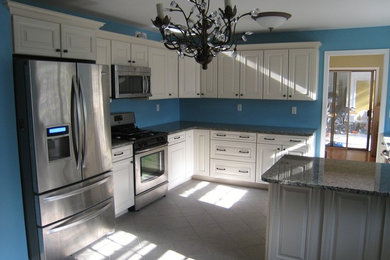 Large traditional l-shaped eat-in kitchen in New York with an undermount sink, raised-panel cabinets, white cabinets, granite benchtops, stainless steel appliances, ceramic floors and a peninsula.