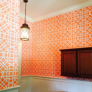 Design ideas for a small bohemian cloakroom in Charleston with raised-panel cabinets, dark wood cabinets and orange walls.