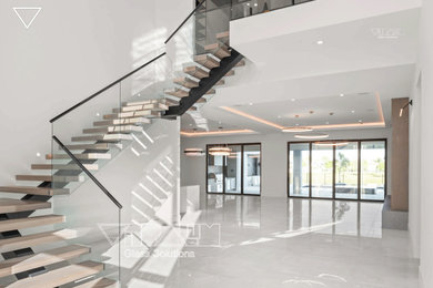 Diseño de escalera suspendida moderna grande con escalones de vidrio
