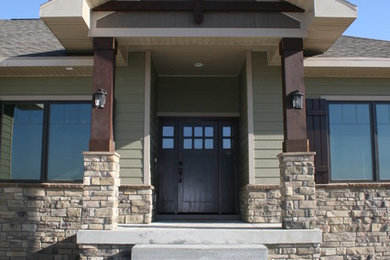 Example of a mid-sized mountain style green one-story mixed siding house exterior design in Omaha with a hip roof and a shingle roof